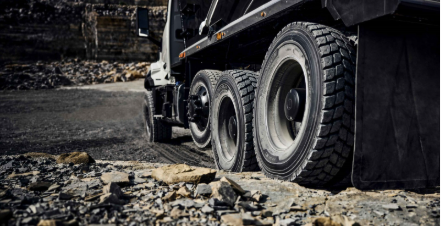A close up view of the Volvo VNX's wheels on a rocky road from behind.