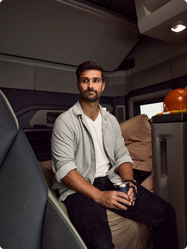 A man sitting down in the sleeper environment of the Volvo VNX.
