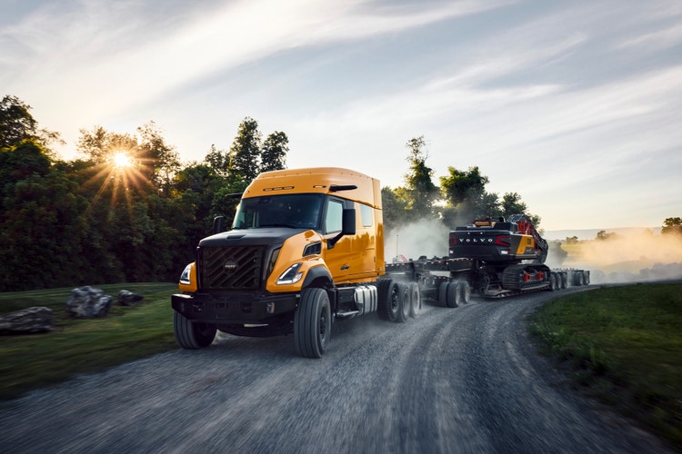 A yellow color Heavy-Duty Volvo VNX truck in motion.