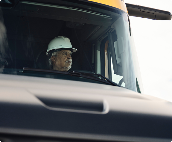 A close-up view of a driver behind the wheel of a Volvo VNX