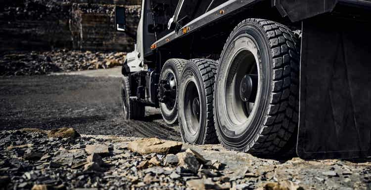 A view of the tires and mudflaps of the Volvo VNX from the behind on a rocky ground.