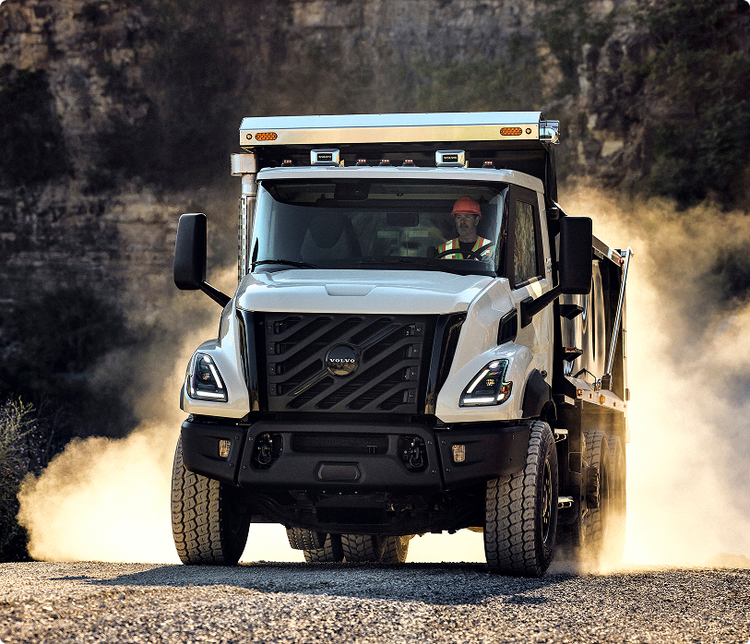 A front view of the Volvo VNX as it drives on a rocky road and the smoke passes behind the truck.