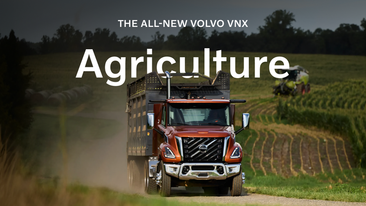 A red colored Volvo VNX on a narrow road surrounded by greenery with the text overlay that reads, "The All-New Volvo VNX. Agriculture."