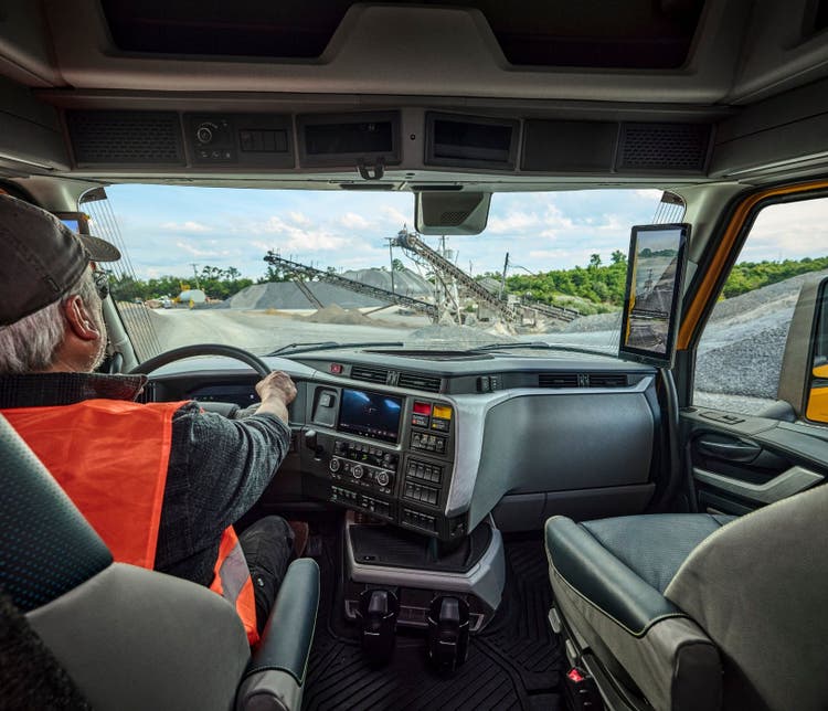 A man driving a Volvo VNX to a constuction site. A behind the driver point of view.